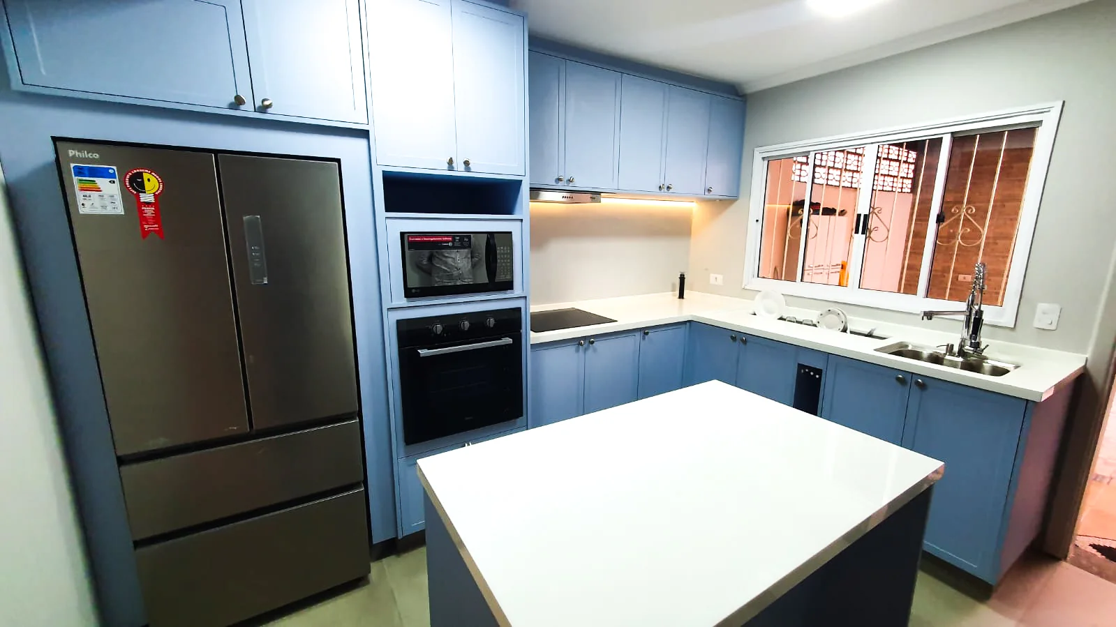 Foto de cozinha planejada com ênfase nos tons branco e azul claro.