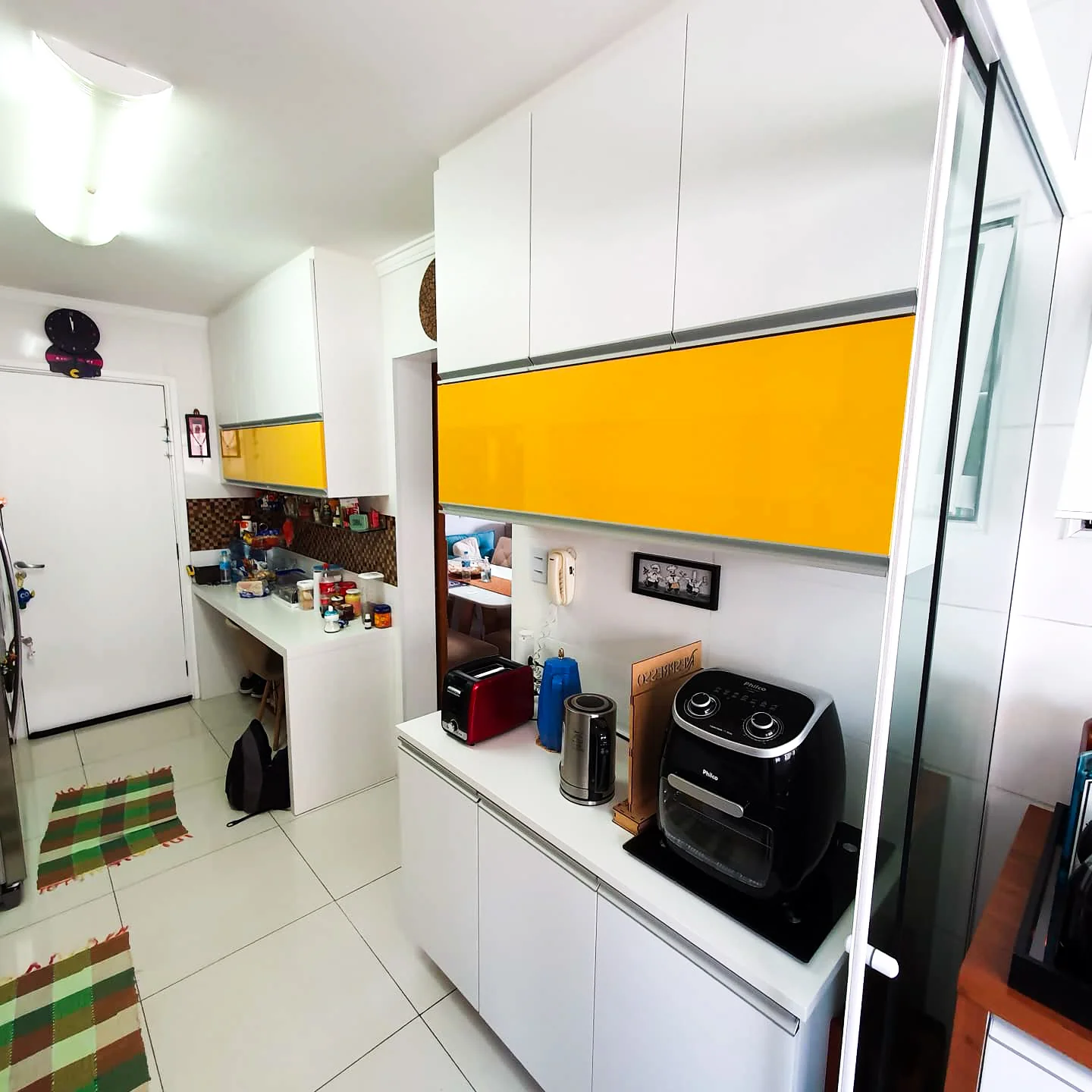 Foto de cozinha planeja com ênfase nas cores claras como branco e laranja em destaque